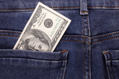 Kot pantolonun cebinde yüz dolarlık banknot. Tasarruf, yatırım, kazanç kavramı. miras
