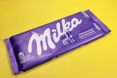 Magdalinovka, Ukraine - February 16, 2022. Milka alpine milk chocolate on a yellow background