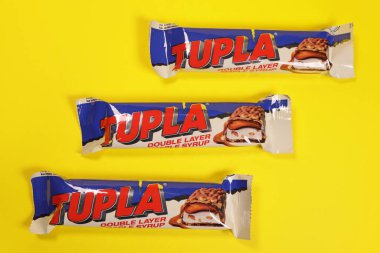 Magdalinovka, Ukrayna - 1 Mart 2022. Parlak sarı arka planda akçaağaç şuruplu Tupla çikolatası.