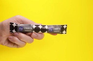 Magdalinovka, Ukrayna - 1 Mart 2022 Meyan kökü şekeri Lakritsi Fazer 'den elde sarı arka planda