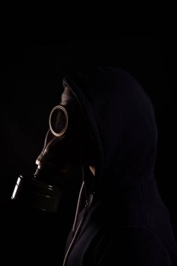 Siyah arka planda gaz maskeli bir adam, çevre kirliliği kavramı, kıyamet sonrası.