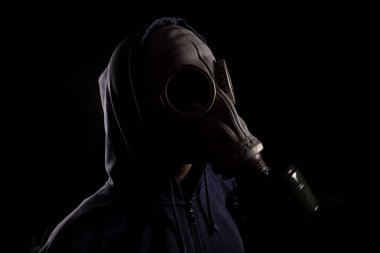Gaz maskeli bir adam, hava kirliliği kavramı, kimyasallarla dolu bir çevre.