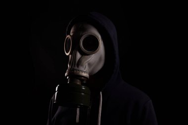 Siyah arka planda gaz maskeli bir adam, çevre kirliliği kavramı, kıyamet sonrası.