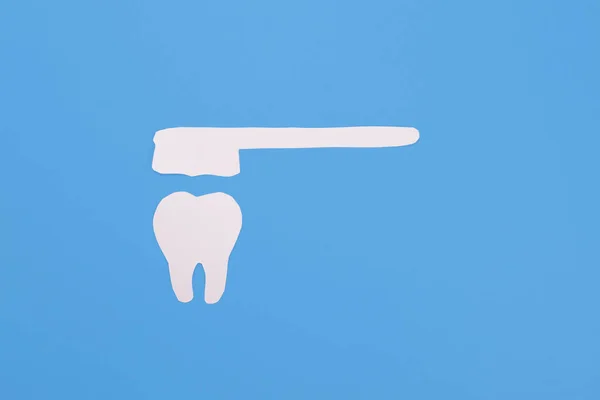 青い背景に紙の歯と歯ブラシ 歯科衛生の概念 — ストック写真