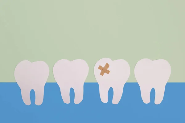 青い背景に羊飼いが封印した白い紙の歯 歯科治療 歯科サービスの概念 — ストック写真