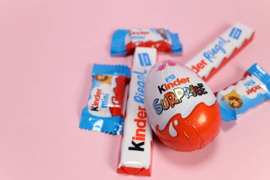 Magdalinovka, Ukrayna - 3 Mart 2023. Çikolata ürünleri Kinder Sürprizi, Kinder Riegel ve Kinder Mini pembe arka planda