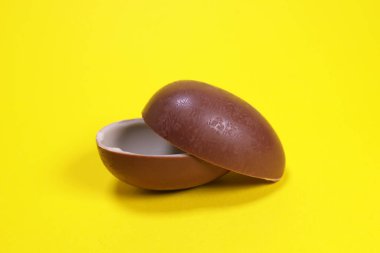 Magdalinovka, Ukrayna - 4 Mart 2023. Ferrero 'nun sürpriz çikolatalı yumurtası sarı arka planda açıldı.