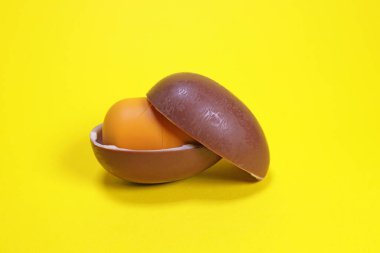 Magdalinovka, Ukrayna - 4 Mart 2023. Ferrero 'nun sürpriz çikolatalı yumurtası sarı arka planda açıldı.