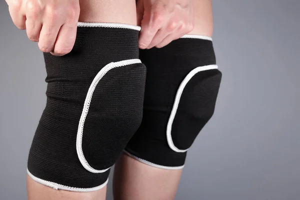Woman Puts Protective Sports Knee Pads Stock Photo