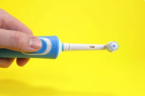 Modern Electric Toothbrush Hand Yellow Background Oral Hygiene Concept — Stock Photo, Image