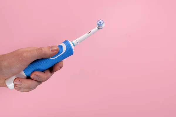 Σύγχρονη Ηλεκτρική Οδοντόβουρτσα Στο Χέρι Ροζ Φόντο Στοματική Υγιεινή Έννοια — Φωτογραφία Αρχείου