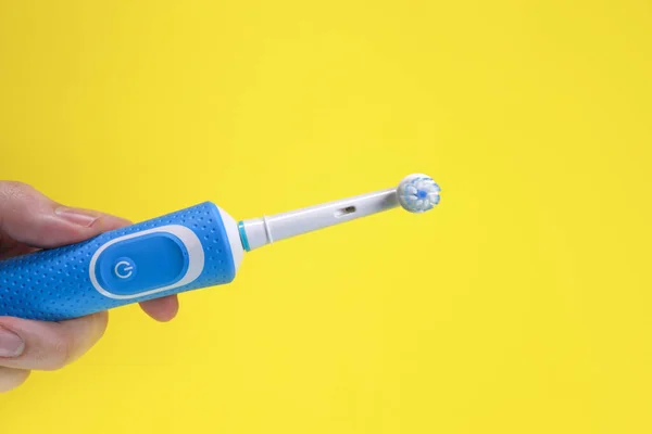 Electric Toothbrush Hand Yellow Background Oral Hygiene Concept — Stock Photo, Image