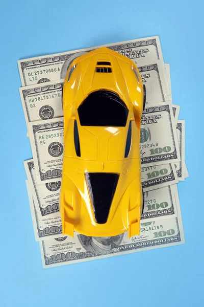 Toy car on dollar bills, concept of content auto insurance, repair, checkup
