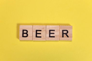 Sarı arka plandaki tahta harflerden bira sözcüğü.