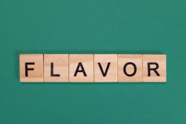 Yeşil arka plandaki ahşap harflerden yapılmış lezzetli bir kelime.