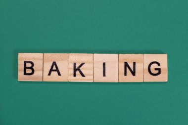 Yeşil arka planda ahşap harflerden kelime pişiriyorum.