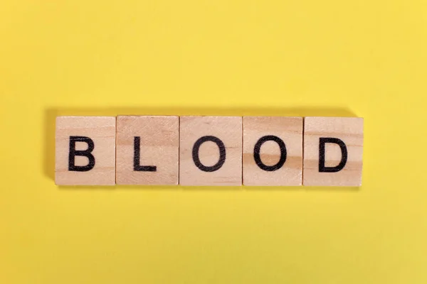 Krwawe Słowo Drewnianych Liter Żółtym Tle — Zdjęcie stockowe