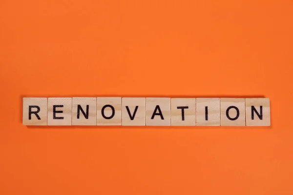 stock image Renovation word from wooden letters on orange background