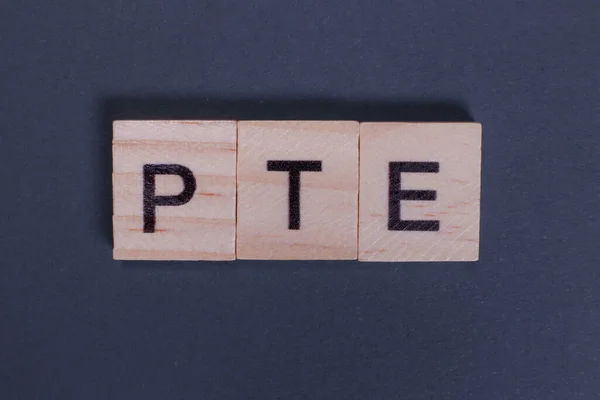 Pte皮尔逊灰色背景的木制字母英语测试 — 图库照片