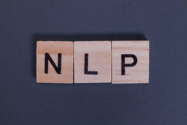 Gri arkaplandaki ahşap harflerden doğal dil işlemesi için NLP kısaltması