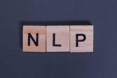 NLP short for Natural Language Processing from wooden letters on a gray background clipart