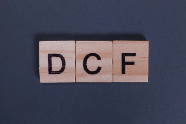Discounted Cash Flow DCF from wooden letters on a gray background