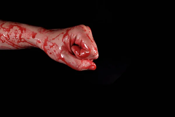 Bloody fist on a black background, the concept of self-defense, murder, nightmares, Halloween