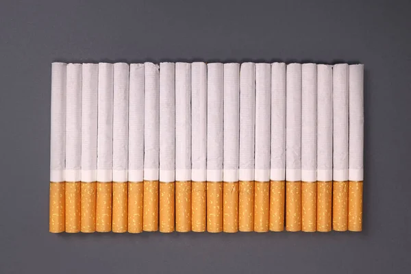 灰色の背景にタバコの列 喫煙の害 ニコチン中毒 — ストック写真