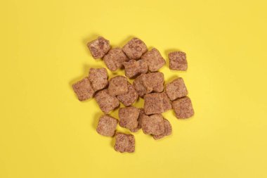 Çikolatalı atıştırmalıklar, sarı arka planda kuru kahvaltı.