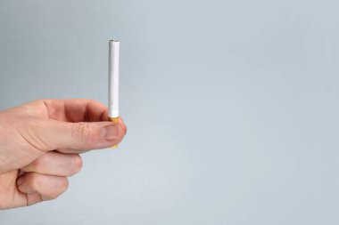 Elinde filtre olan sigara beyaza izole edilmiş.