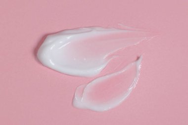 Pembe arka planda vücut ya da yüz kremi, kozmetik ürünleri, cilt bakımı