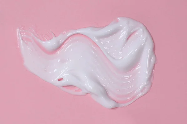 Smear of cream for body or face on a pink background, cosmetics, skincare