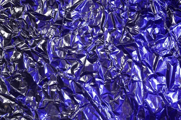 stock image crumpled aluminum foil in blue light, background or texture