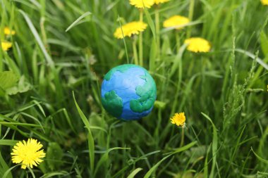 Yeşil çimenlikteki plastikten Dünya gezegeni. Gezegeni kurtar, çevre kavramı