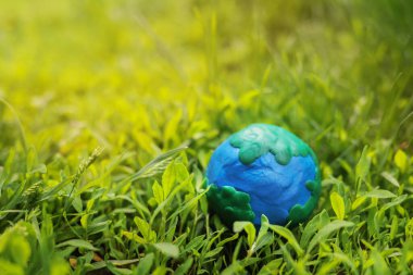 Yeşil çimenlikteki plastikten Dünya gezegeni. Gezegeni kurtarmak, ekolojik çevre kavramı. metin için boşluk kopyala