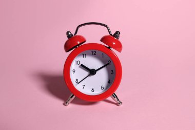 Pembe arka planda kırmızı alarm saati