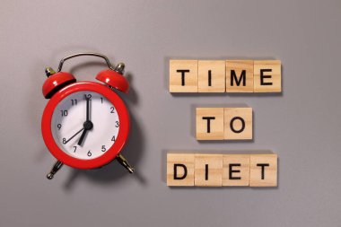 Gri arkaplanda diyet yazma ve alarm saati zamanı