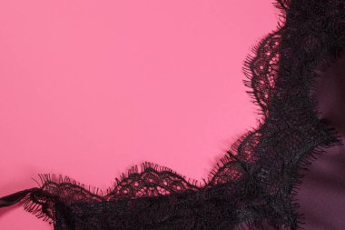 Pembe arka planda ipek elbiseli siyah dantel. metin için boşluk kopyala