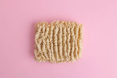 Pembe arka planda kuru pişmemiş hazır şehriye.