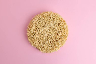 Pembe arka planda kuru pişmemiş hazır şehriye.