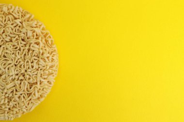 Sarı arka planda kurutulmuş hazır makarna. metin için boşluk kopyala