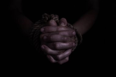 Kadının elleri siyah arka planda iple bağlanmış. Kurbanın aile içi şiddet kavramı.