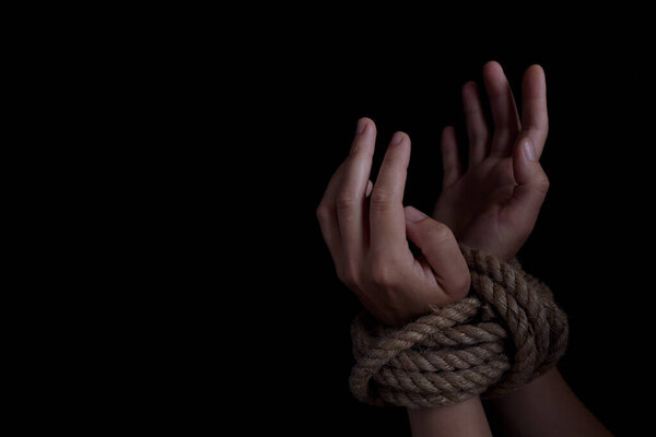 Woman with hands tied with rope, concept of violence, woman's rights. copy space for text