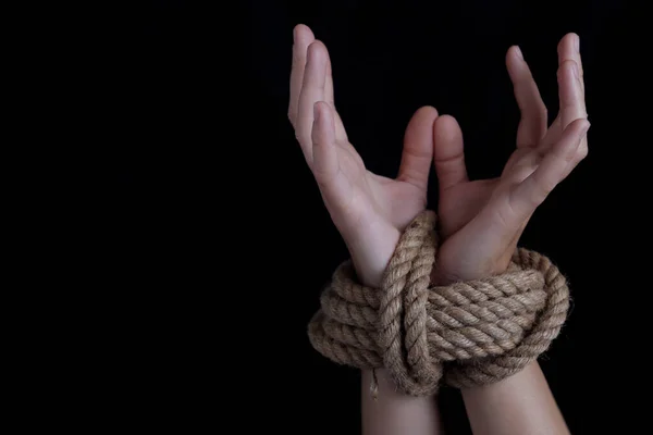 Woman with hands tied with rope, concept of violence, woman's rights