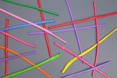 gri arka planda renkli lateks kıvrımlı renkli balonlar