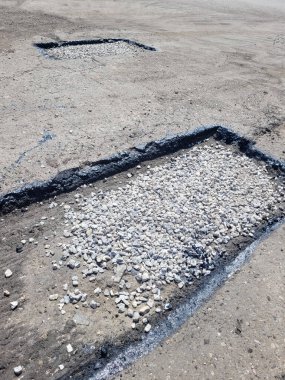 Şehirdeki bir yolda asfalt çukuru tamir etme işlemi. Dikey Yönlendirme