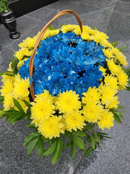 Bouquet of flowers on the memorial plaque of Ukrainian soldiers in the war with Russia. Vertical Orientation