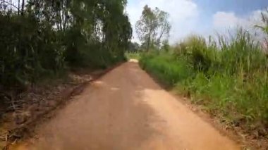 4x4 off road pikap tekerlekleri toprak bir yolda çalışıyor. Kirli yolda çamurlu, ıslak ve kuru çamurla hareket eden off-road kamyon tekerlekleri. Bakış açısına göre 4WD kamyon lastiği taşrada seyahat ediyor.