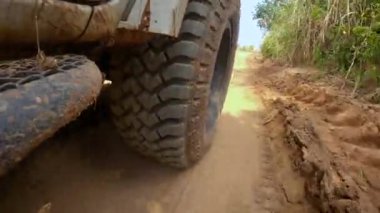 Point of view running on a dirt road. Off-road truck car wheels move on the dirty road with dust, wet and dry mud.  Point of view travel in the backcountry place