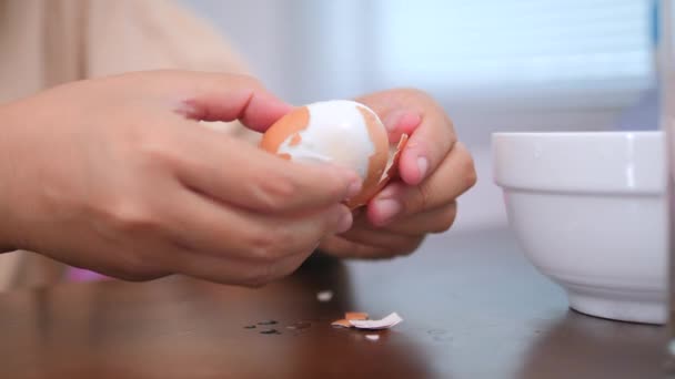一个女人的手剥去了那个褐色鸡蛋的皮 煮熟的鸡蛋剥去蛋皮 — 图库视频影像
